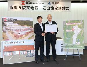 進出協定を結んだ岩塚製菓の槇大介社長(左)と長岡市の磯田達伸市長=28日、アオーレ長岡