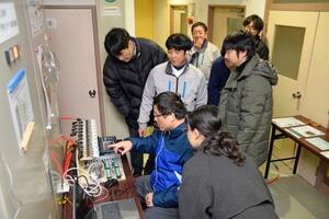 放射線防護施設で測定した気圧を確認する研究チーム=14日午後、新潟県柏崎市