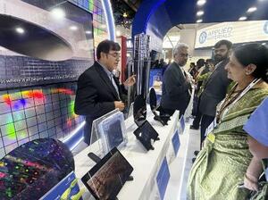 半導体の国際展示会「セミコン・インディア」で、展示品の説明をする半導体関連企業の担当者(左)=昨年9月、インド・ニューデリー