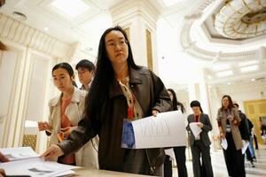 中国国家統計局のGDP速報値に関する資料を受け取る報道関係者ら=16日、北京(共同)