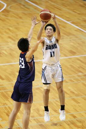 男子決勝リーグ　佐渡－北越　第３クオーター、佐渡の垣並大哉（右）が３点シュートを放つ＝新潟市東総合スポーツセンター