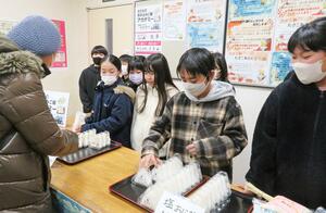 サザエの炊き込みご飯を販売する出雲崎小学校の児童=出雲崎町尼瀬