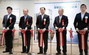 　式典でテープカットする警視庁の久田誠総務部長（中央）ら＝１９日、東京都中央区の警察博物館「ポリスミュージアム」