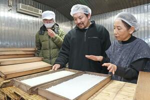 工場でこうじの状態を見る柳和子さん(右)とSUZUグループの鈴木将社長(中央)=長岡市吉崎の柳醸造