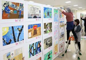 県ジュニア美術展覧会上越展の開幕を前に行われた準備作業＝２８日、上越市土橋