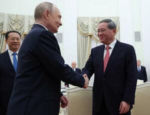 　中国の李強首相（右）と握手するロシアのプーチン大統領＝１８日、モスクワ（ロイター＝共同）