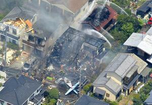 東京都調布市の住宅街に墜落した小型プロペラ機(下)=2015年7月26日