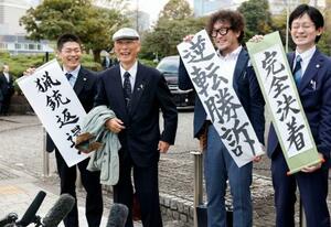 　猟銃所持許可取り消しを巡る訴訟の最高裁判決で勝訴し、笑顔を見せる北海道猟友会砂川支部長の池上治男さん（左から２人目）ら＝２７日午後、東京都千代田区