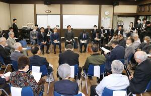 車座になり新潟水俣病被害者と意見交換する国定勇人環境政務官(中央奥)=5月31日、新潟市北区