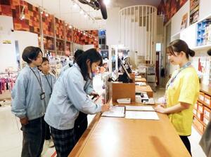 　税務調査を体験する小学６年生ら（左）＝１１日午前、東京都江東区の「キッザニア東京」