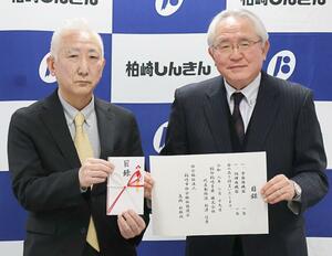 寄付をした柏印柏崎青果の新澤信廣社長（左）と市社会福祉協議会の髙橋敏郎会長＝柏崎市東本町１