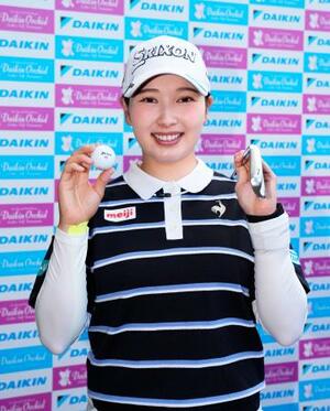 　第２日、１３番でホールインワンを達成し、クラブとボールを手に笑顔の小祝さくら。通算３アンダーで１３位＝琉球ＧＣ