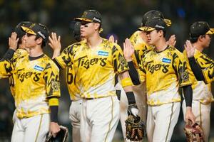ヤクルトに勝利し、タッチを交わす(手前右から)小幡、佐藤輝、近本ら阪神ナイン=甲子園
