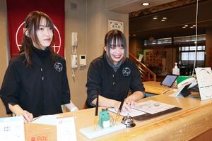 じょんのび村の受付業務を担うインターンシップ生のサムルアムジャイ・ショーシターさん(右)と白石愛純さん=柏崎市高柳町高尾