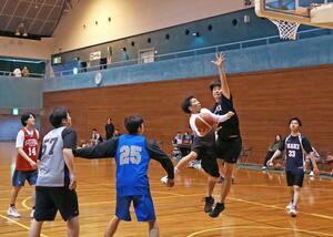 シュートやパスで好プレーを繰り広げた市民バスケットボール大会＝柏崎市半田１