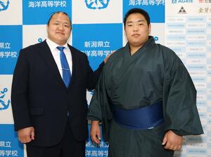 写真撮影に応じるフセルバートル（右）と大山親方＝２１日、糸魚川市の海洋高