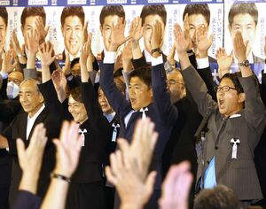 当選確実となり万歳する小林一大さん(右から2人目)=7月10日、新潟市中央区