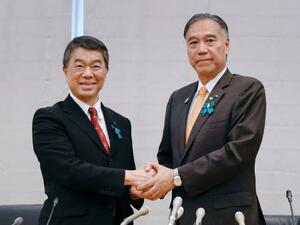 全国知事会会長の村井嘉浩宮城県知事(左)と握手する、新会長に選ばれた阿部守一長野県知事=26日午後、東京都千代田区