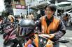 　バンコク中心部の待機場所に愛車のバイクを止めるオッド。「田舎から出てきたやんちゃな男が多い」という運転手仲間をうまくまとめる秘訣（ひけつ）はこの優しい笑顔だ＝２０２６年３月（撮影・浮ケ谷泰、共同）
