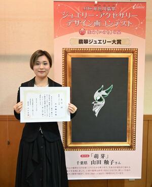 大賞を受賞した山田釉子さんと作品「萌芽」=糸魚川市のヒスイ王国館