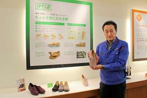 アサヒシューズのシニア向け靴を紹介する塚本栄治執行役員=福岡県久留米市