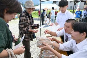 地域おこし協力隊員と考案した笹ずしを販売する高校生ら=糸魚川市山口