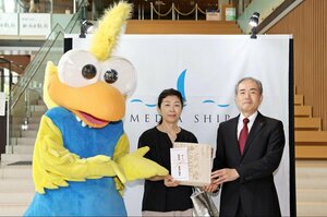 新潟日報メディアシップ来館者1500万人目の記念品を受け取った渡邊幸子さん(中央)=9月6日、新潟市中央区