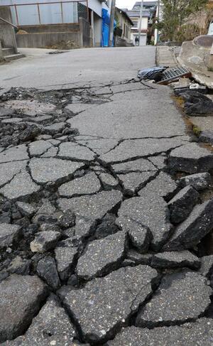 波打ち、大きな亀裂が入ったままの私道。復旧に頭を悩ませる住民は多い=新潟市西区