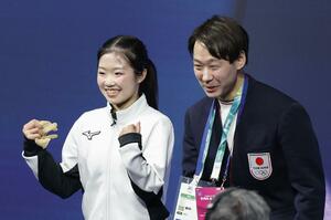 フィギュアスケート女子SPの得点を確認し、喜ぶ中井亜美(左)と中庭健介氏=17日、イタリア・ミラノ(共同)
