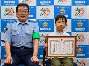 大阪府警箕面署から感謝状を贈呈され、写真に納まる今津心之介さん(右)=20日午後