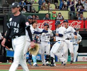 10回、サヨナラ本塁打を放ちチームメートに迎えられる西武・林安可(右から2人目)。手前は打たれたロッテのロング=ベルーナドーム
