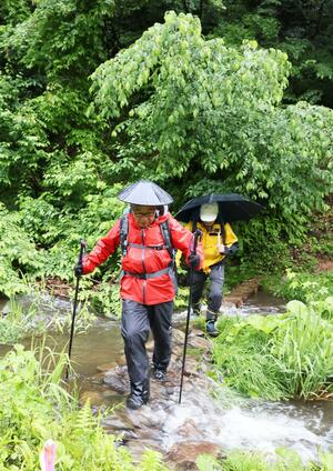 山開きした守門岳の沢を渡る登山者=6月15日、長岡市入塩川