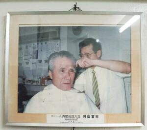村山富市元首相が通っていた理容室に飾られている写真=17日午後、大分市