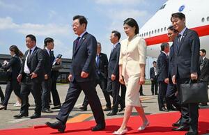 羽田空港に到着した韓国の李在明大統領(中央左)と妻の金恵景氏=23日午前