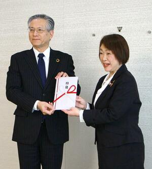 県フードバンク推進協議会の山下浩子理事長（右）に目録を手渡す第四北越ＦＧの殖栗道郎社長＝新潟市中央区