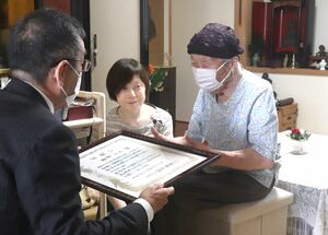 長寿を祝ってお祝い状などを贈られる唐沢トクさん=柏崎市中央町