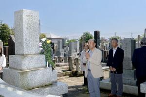 石川雲蝶の墓前で手を合わせる三条雲蝶会の会員ら=三条市西本成寺1