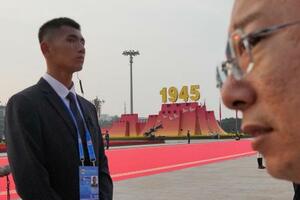 抗日戦争勝利80周年の軍事パレード当日に北京の天安門広場で警戒する治安当局者(左)=9月(共同)