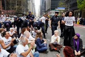 　１３日、米ニューヨーク・マンハッタンで、通りに座り込むデモ参加者ら（共同）