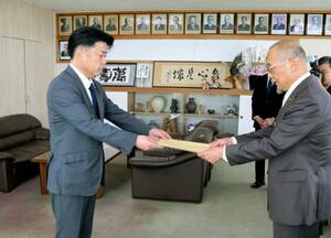市議会議長に辞職届を提出する福岡県田川市の村上卓哉市長(左)=25日午前、田川市役所