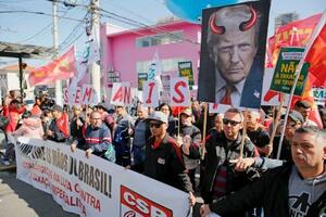 1日、ブラジル・サンパウロの米領事館前で、米国の関税強化に抗議する人たち(共同)