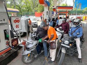 バイクで混雑するインド・ニューデリーのガソリンスタンド=18日(共同)