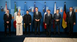 NATO加盟国の首脳らと写真に納まるウクライナのゼレンスキー大統領(左から3人目)=25日、オランダ・ハーグ(ゲッティ=共同)