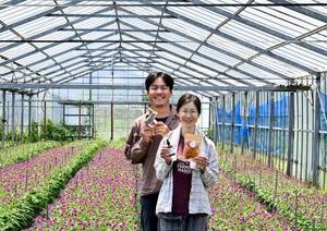 カレンデュラを使った商品を持つ五十嵐大介さん(左)と妻の早矢加さん=6月、千葉県南房総市