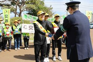 阿賀野署前で、荒木慎弥署長にアンピーちゃんを手渡すＢＢラビッツの金沢みどり選手＝６日、阿賀野市岡山町
