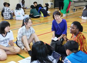 星の杜中学校の生徒と、外国人留学生の交流を見守る高塚苑美さん(右から2人目)=南魚沼市国際町