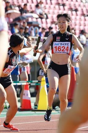 女子１６００メートルリレータイム決勝　１７位の新潟明訓　１走の細川芽愛（右）から２走の石黒果乃（左）へバトンをつなぐ＝７月２９日、広島市