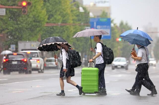 県内に久々の雨 降りしきる雨の中を歩く人たち=5日、新潟市中央区東大通1