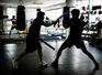 弾力性のある2本のスティックを使い、選手の練習相手を務める八重樫東(中央)=2026年3月、横浜市の大橋ボクシングジム