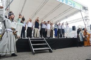 米坂線復活絆まつりで早期復旧に向けて気勢を上げる沿線の市町村長ら=8月31日、山形県小国町